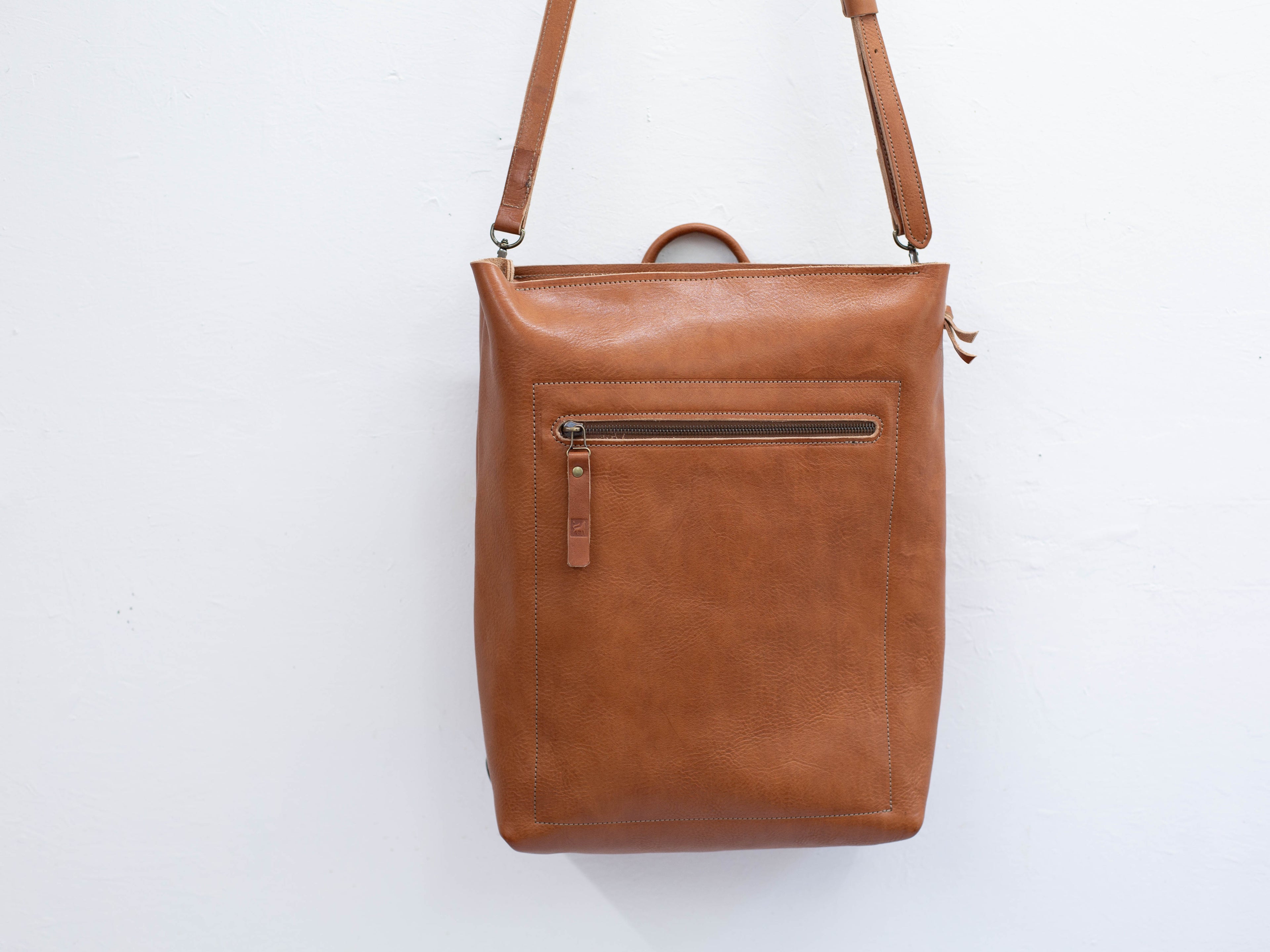 The sustainable leather backpack can be converted to a crossbody messenger bag. 