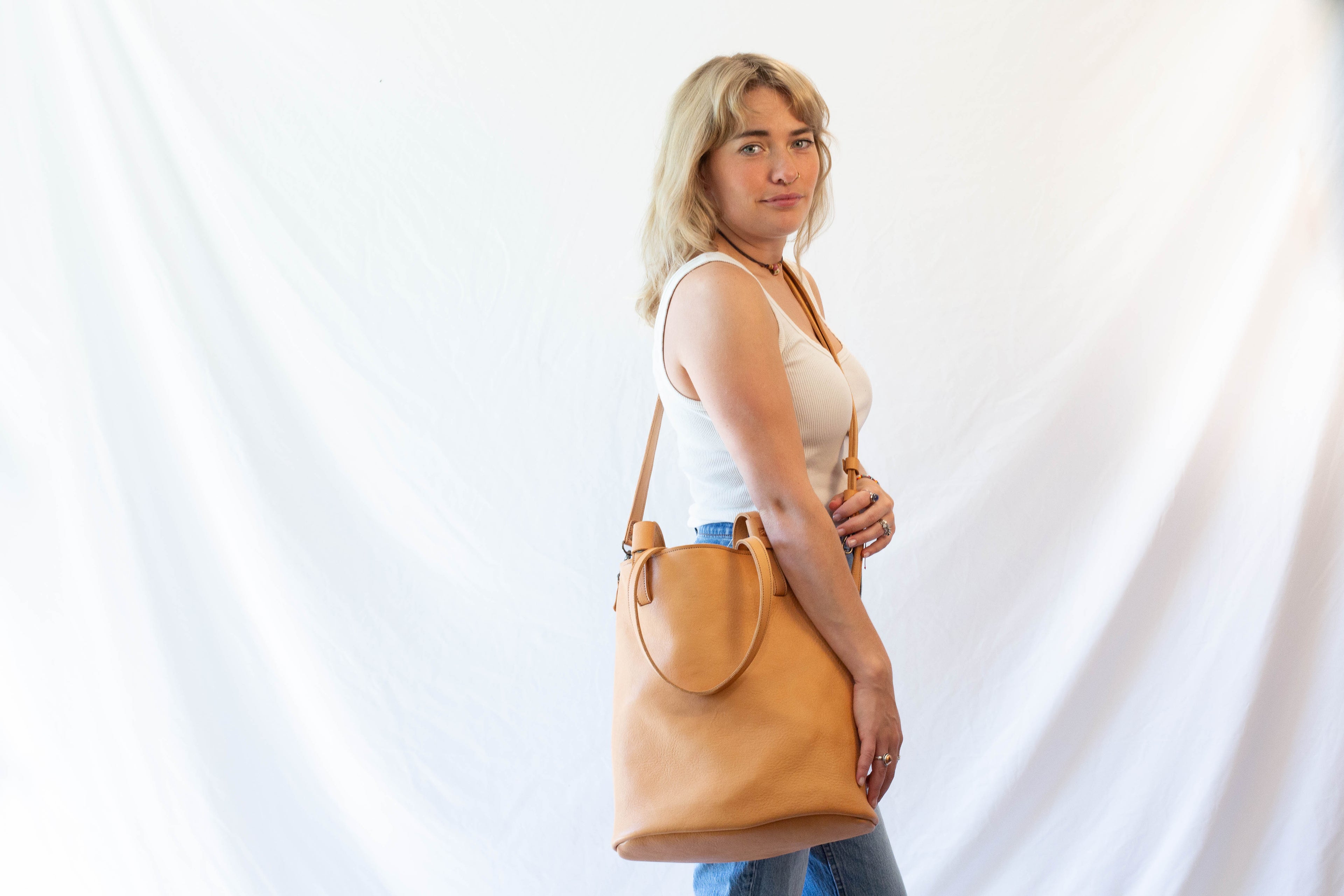 An optional crossbody strap can be attached to the large sustainable leather tote. 