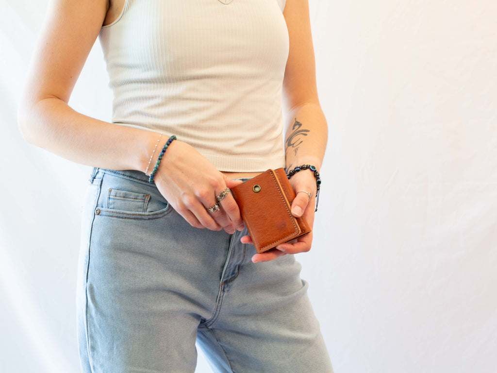 Small leather wallet for cash and cards, closed to see the eyelet for keychain. 