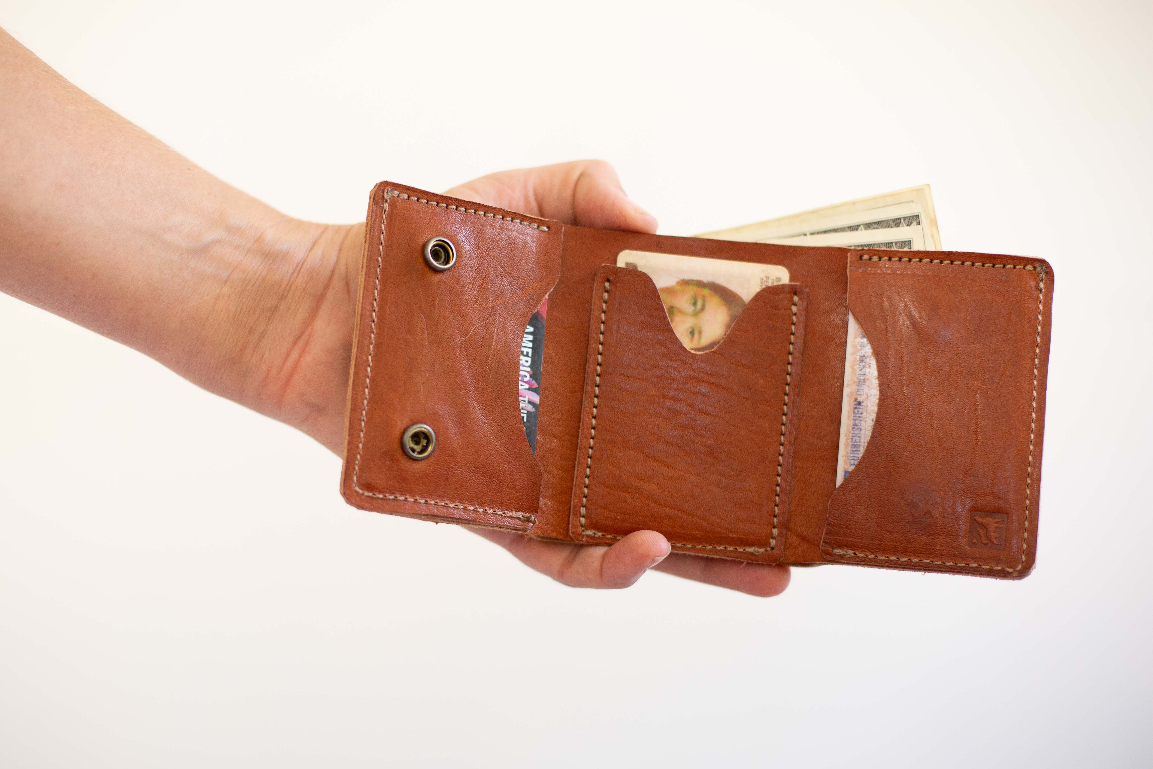 A close-up of the open card and cash wallet to show the compartments, made with sustainable leather. 
