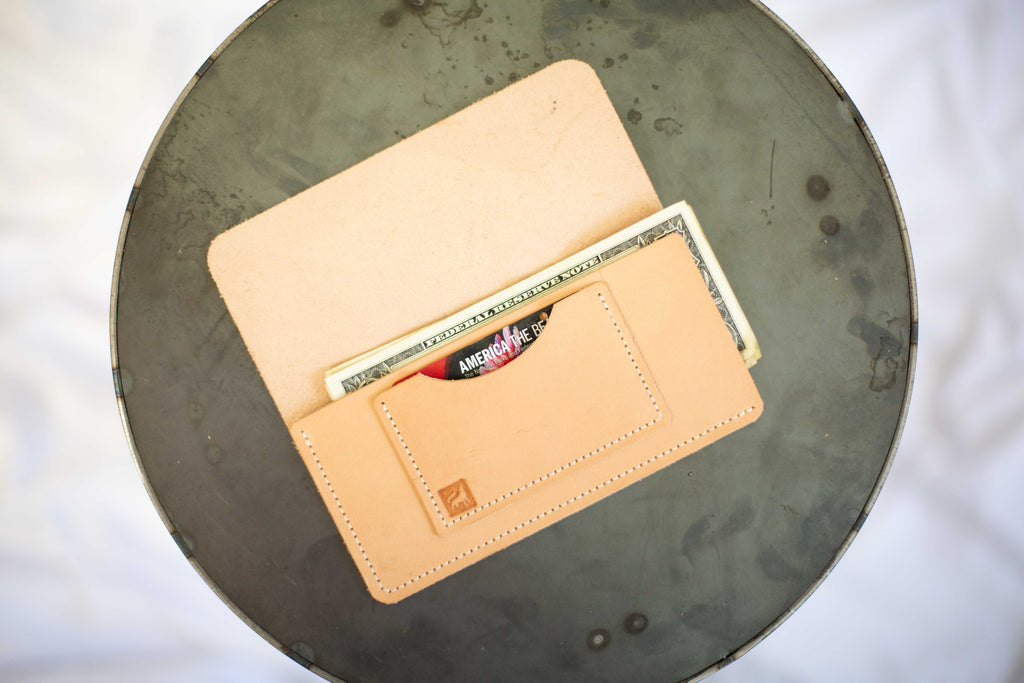 The card holder wallet is open and shows the two compartments - a pocket for a credit or debit card, and the main compartment for cash. 