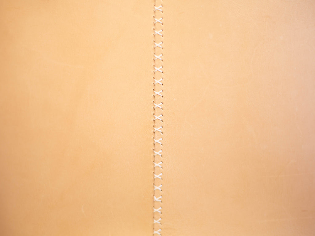A close up of the hand stitched seam on the backside of the veg tan tote. 