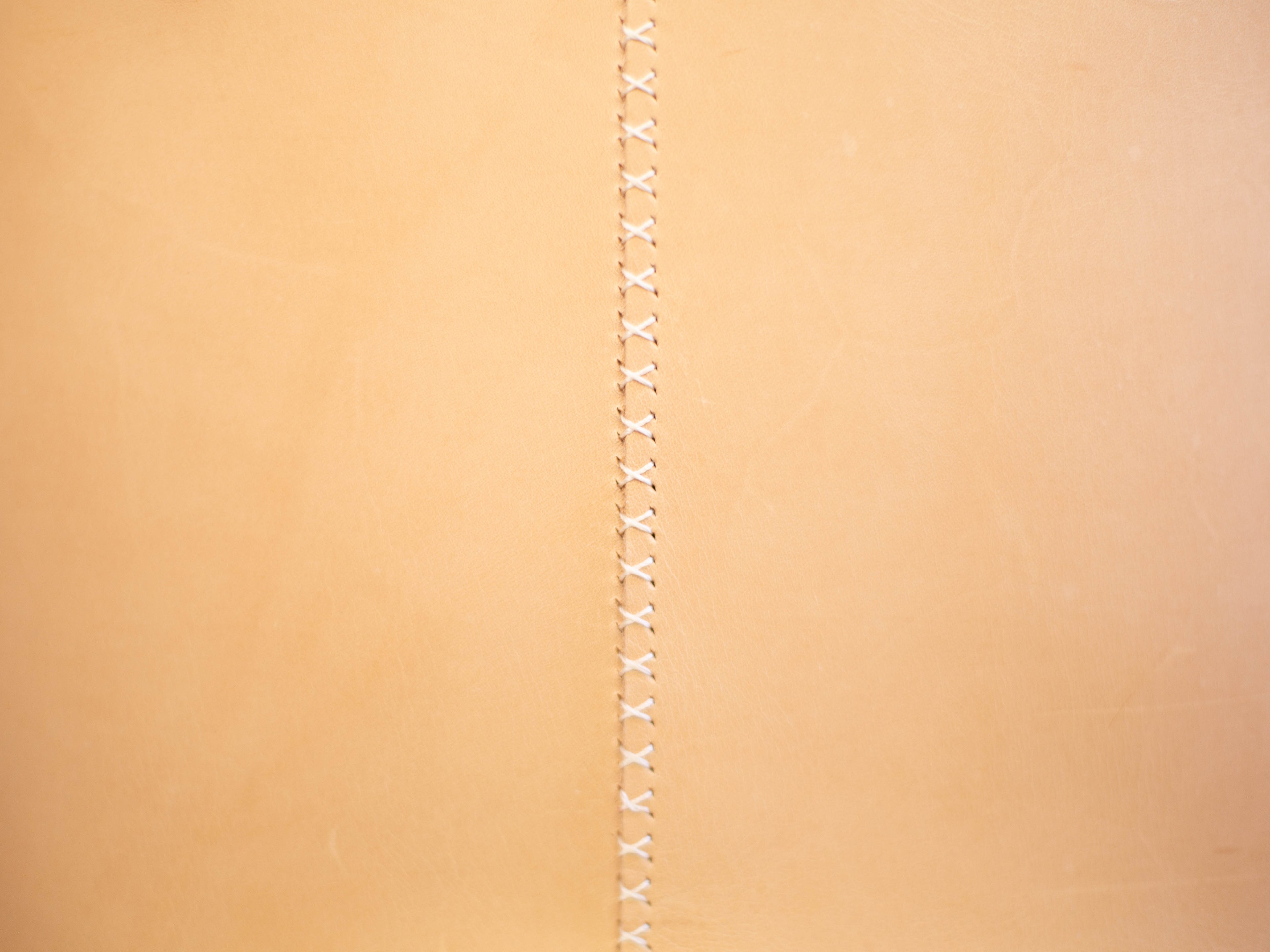 A close up of the hand stitched seam on the backside of the veg tan tote. 