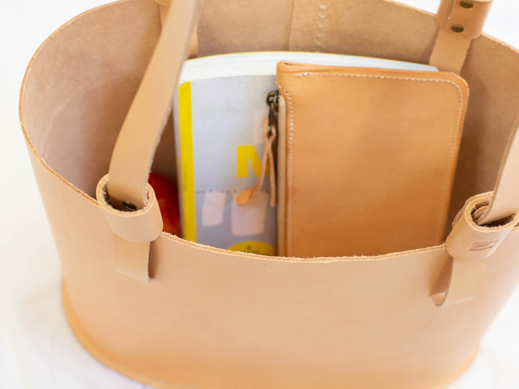 A close-up look to the interior of the veg tan shoulder bag, demonstrating how roomy the interior of the single compartment bag is. 