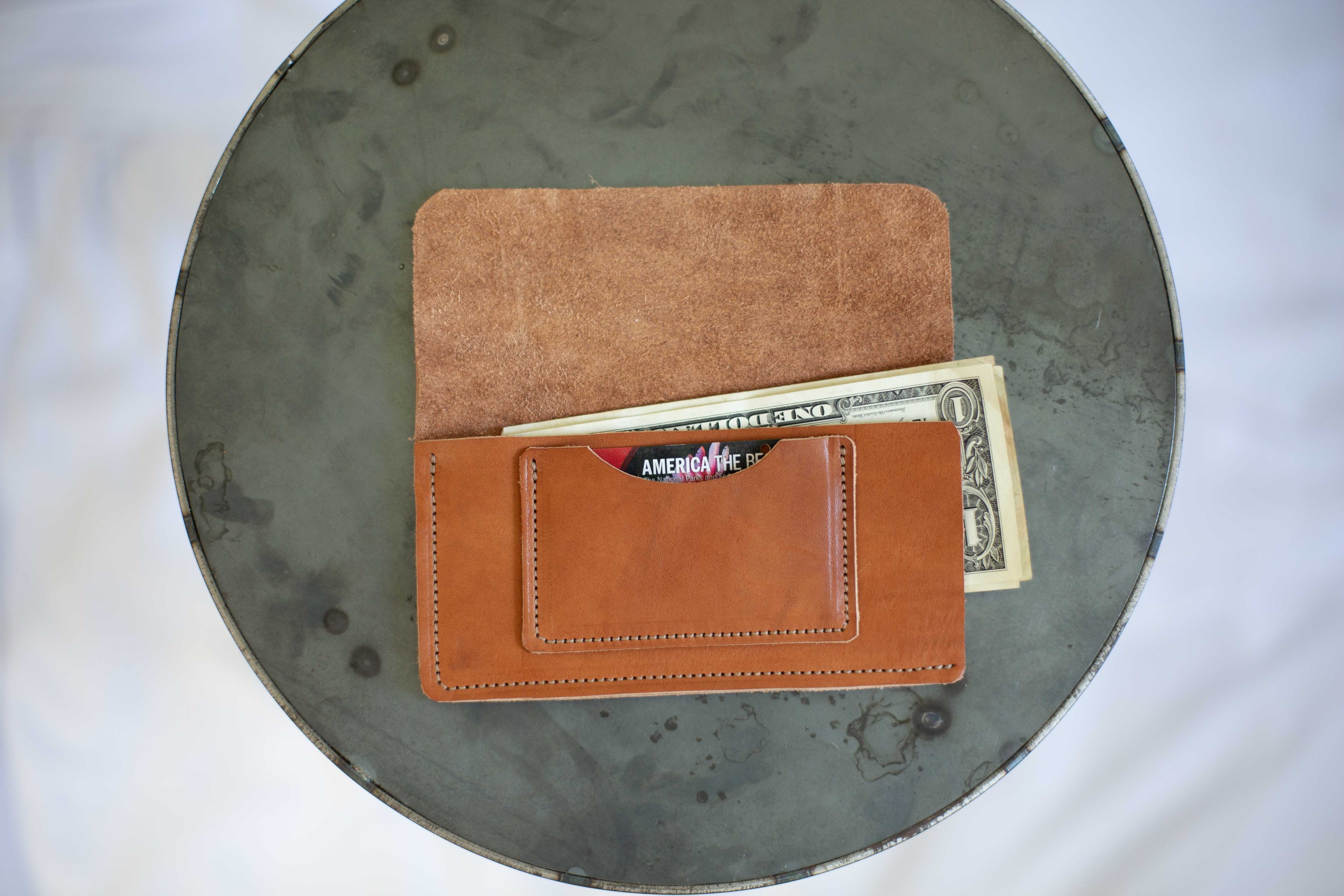 When the sustainable leather wallet is open, you can see the one card pocket and the two open sides for easy access to your cash. 
