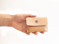 Small leather wallet for coins, closed with snap button and made with organic regenerative veg tanned leather.