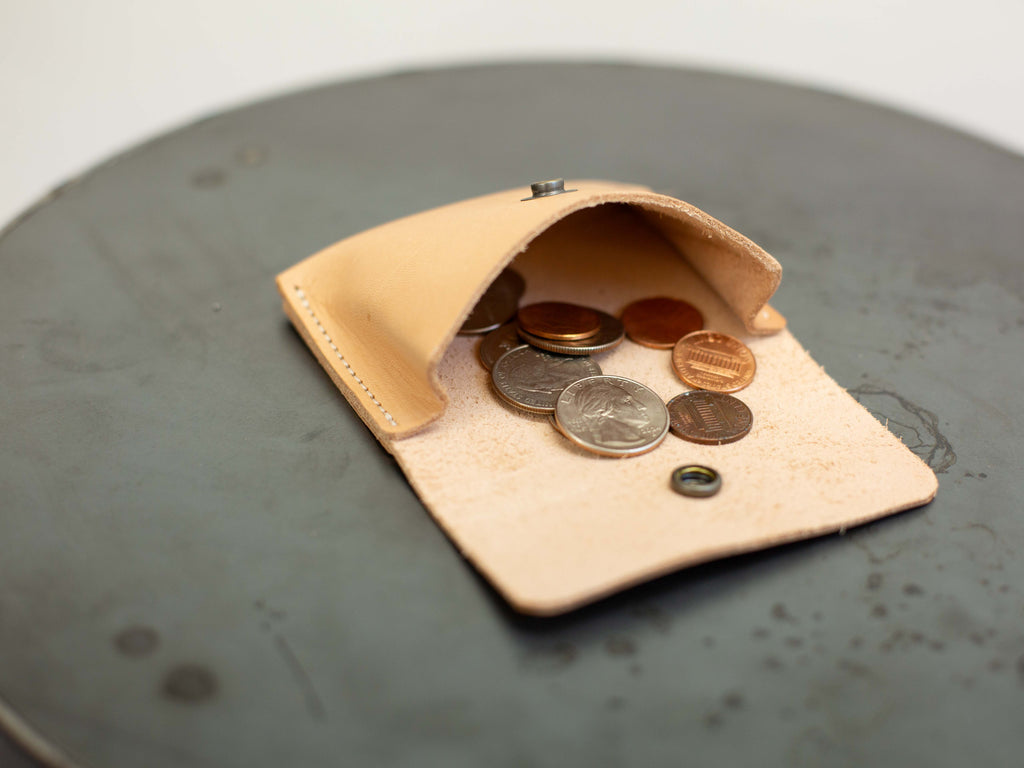 The small leather coin pouch is shown open with coins to show how much room there is in the wallet. 