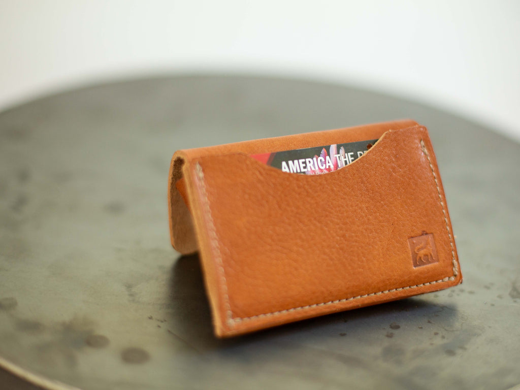 On the back of the small leather coin wallet made with organic leather there is a pocket for a card and the stamped logo of White Wolf Leather Studio. 