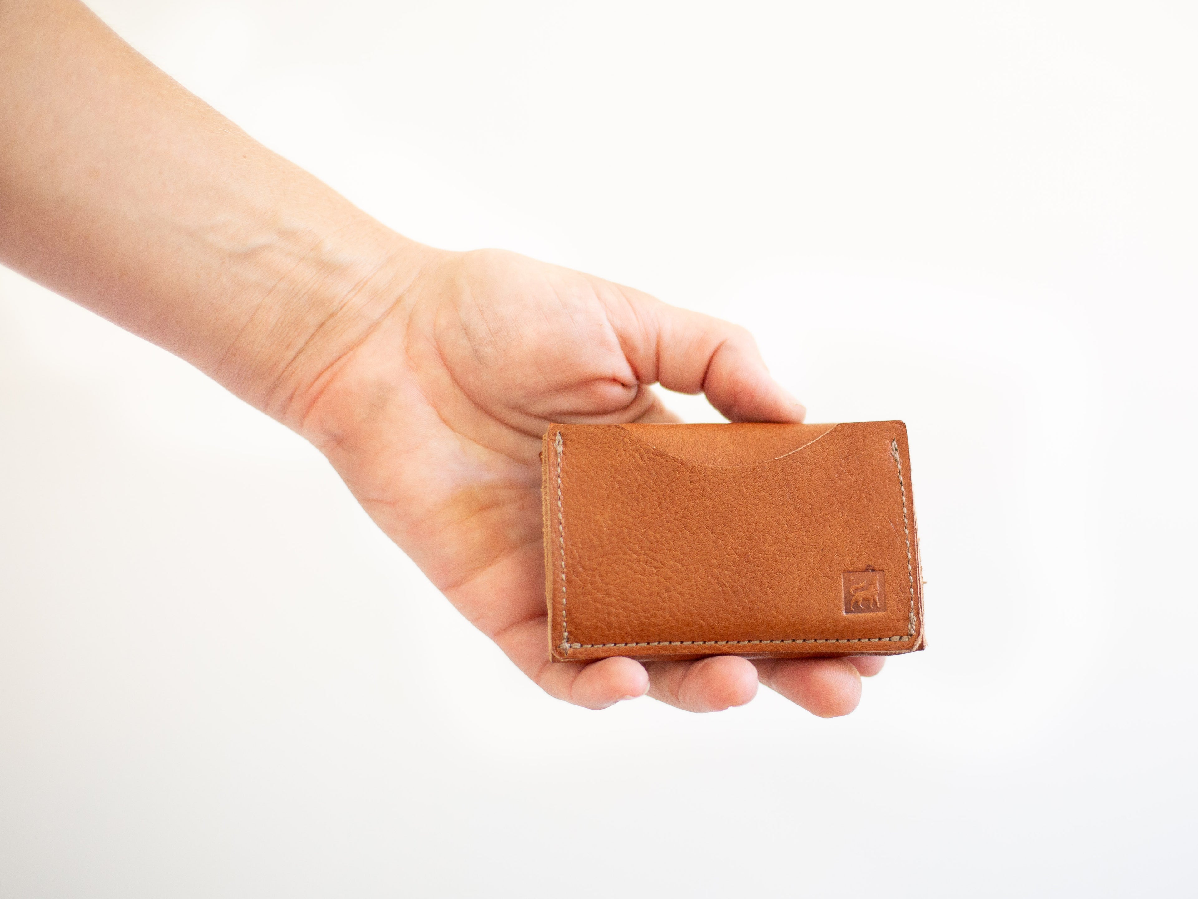 The backside of the wallet has a card pocket and the stamped logo of White Wolf Leather Studio. 