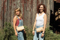 The large and small version of the hand sewn fanny pack is worn by two models. It shows how the leather bag can be worn as a women's purse as well as a fanny pack. 