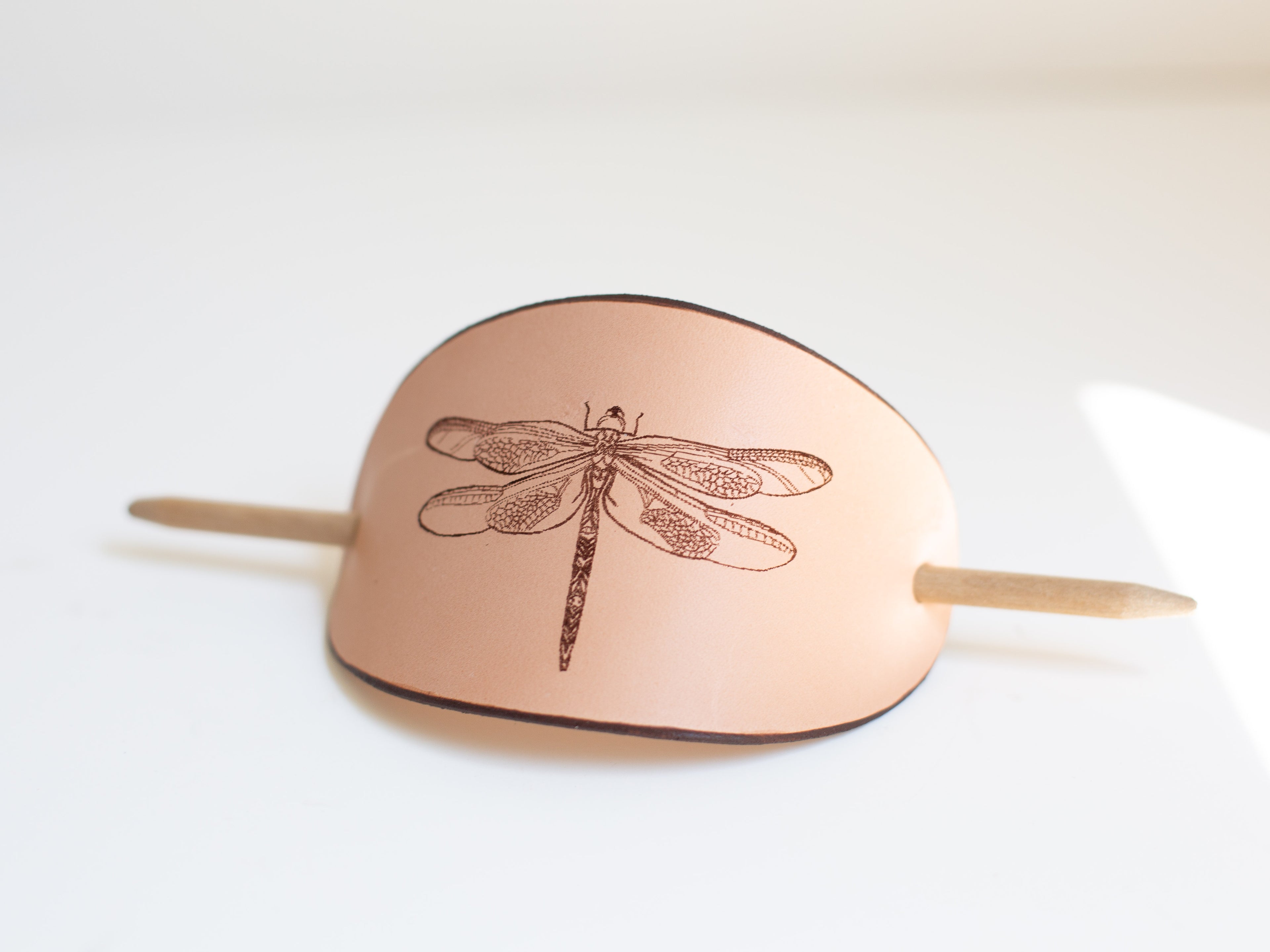 The large leather barrette is made with non-toxic veg tanned leather from organic farming. It has a laser engraved dragonfly design on it. 