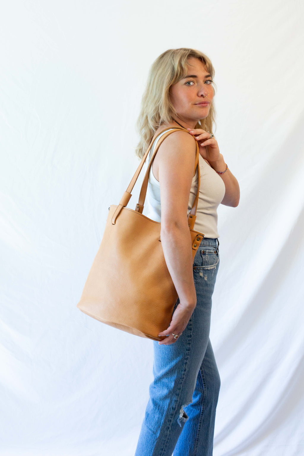 Leather market bag from dark beige leather when worn over the shoulder.