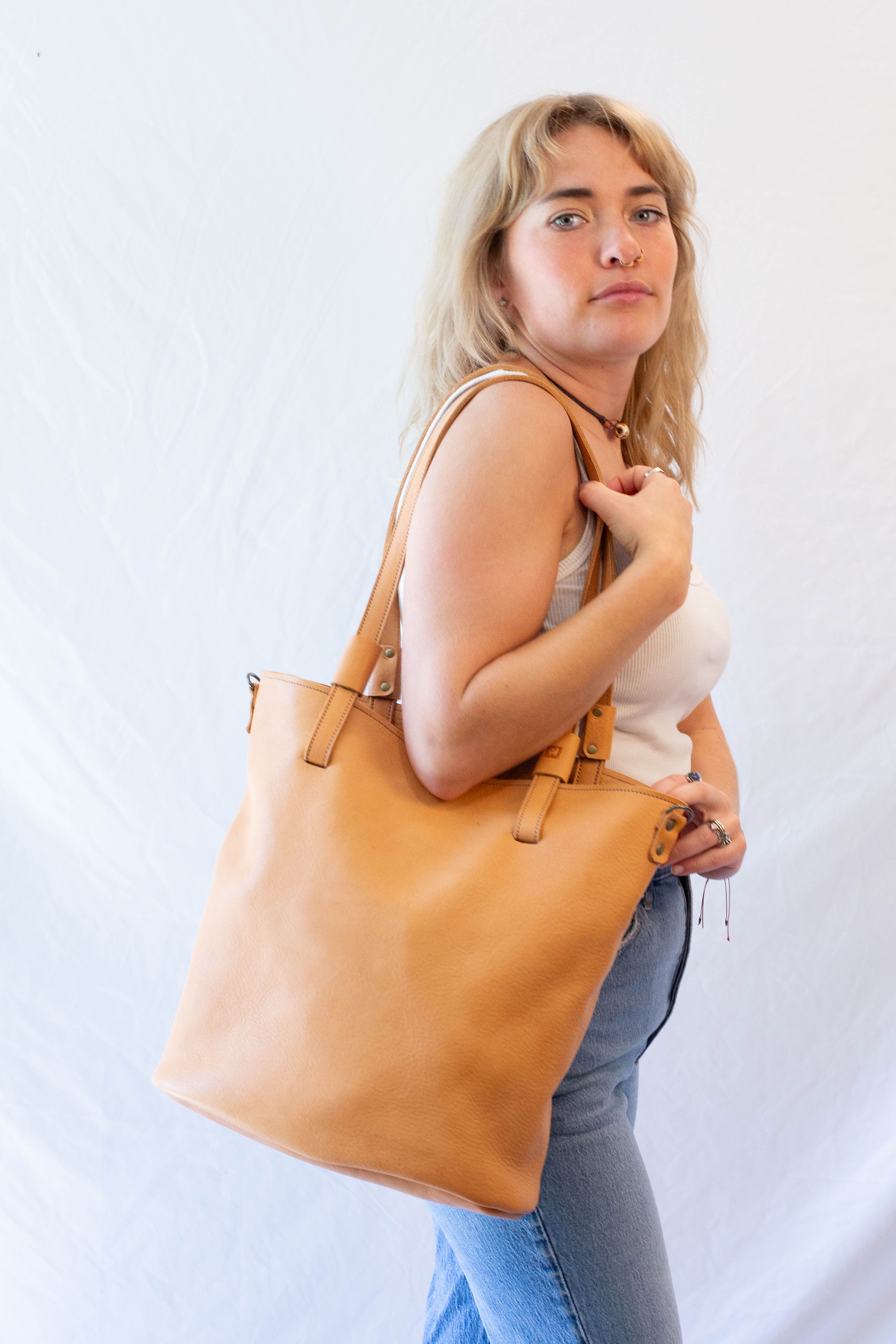 Leather shoulder bag from dark beige leather when in use. 