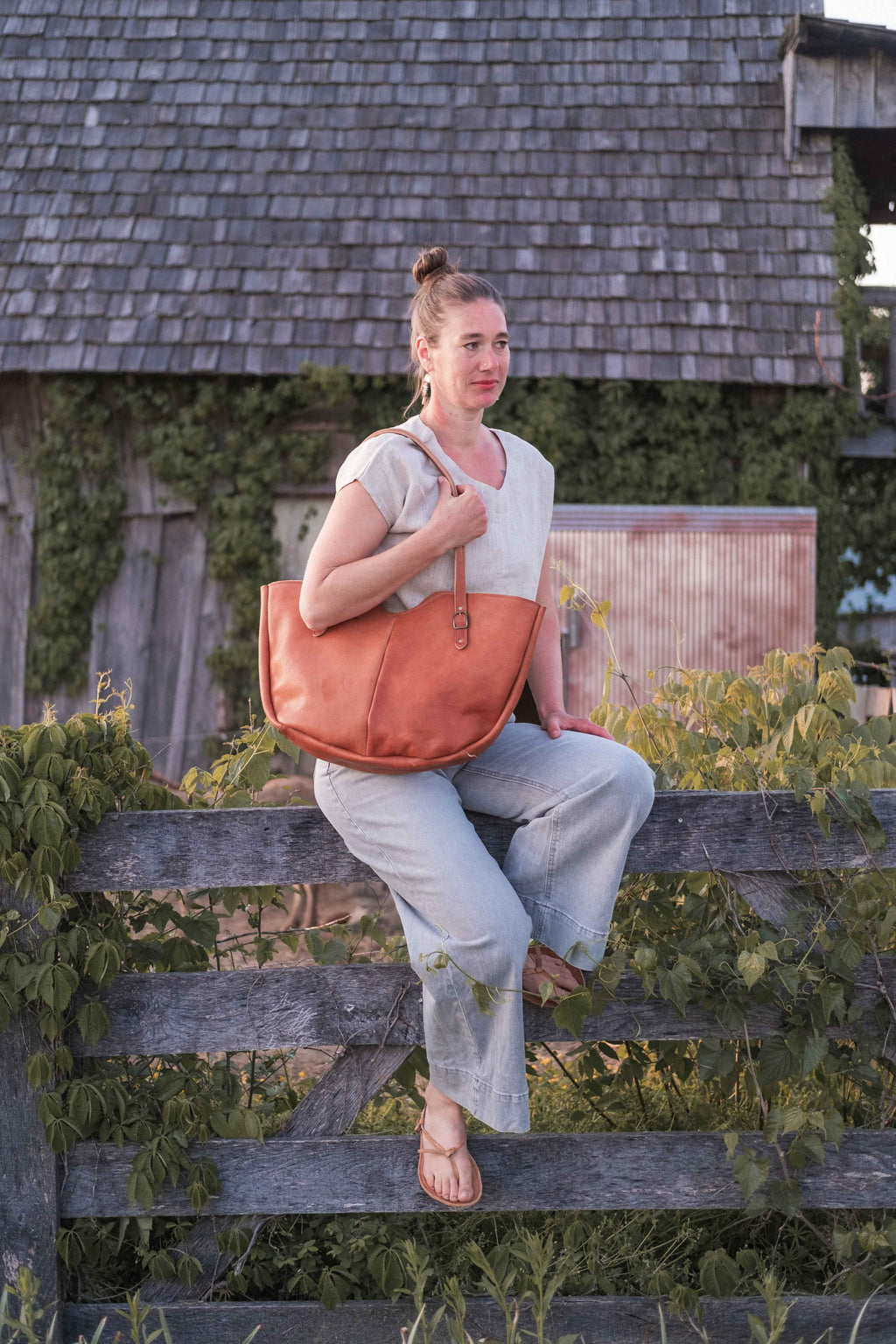 The large leather shoulder bag, model "The Wanderer" is being worn by a model to show how it looks in real life. 
