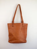 The medium brown leather tote has long shoulder straps to carry it over your shoulder. 