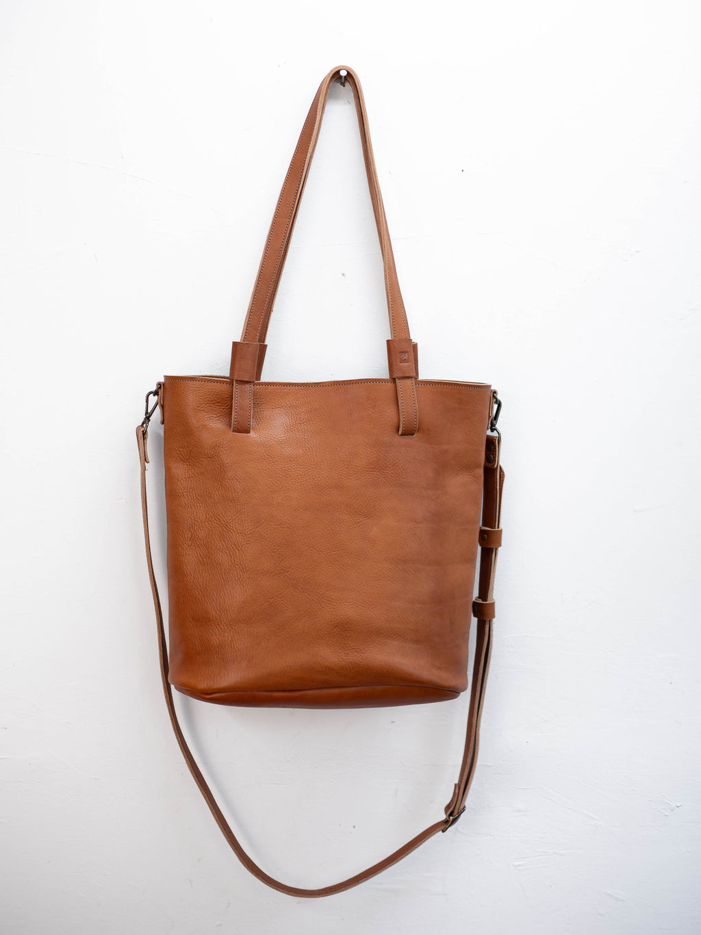 The medium brown leather shoulder bag has a detachable crossbody strap. 