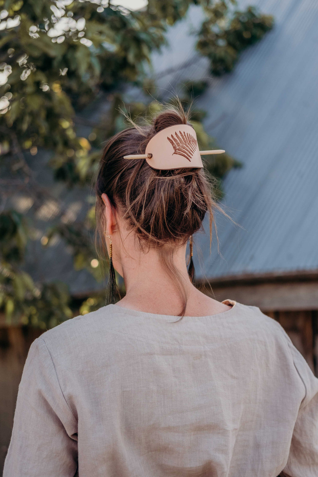 On the photo you can see a styling idea how to wear the large leather barrette with fern laser engraving.