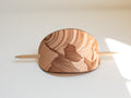 The leather barrette is made with organic leather from hides from cattle from regenerative farms. It has a laser engraved mountain drawing. 
