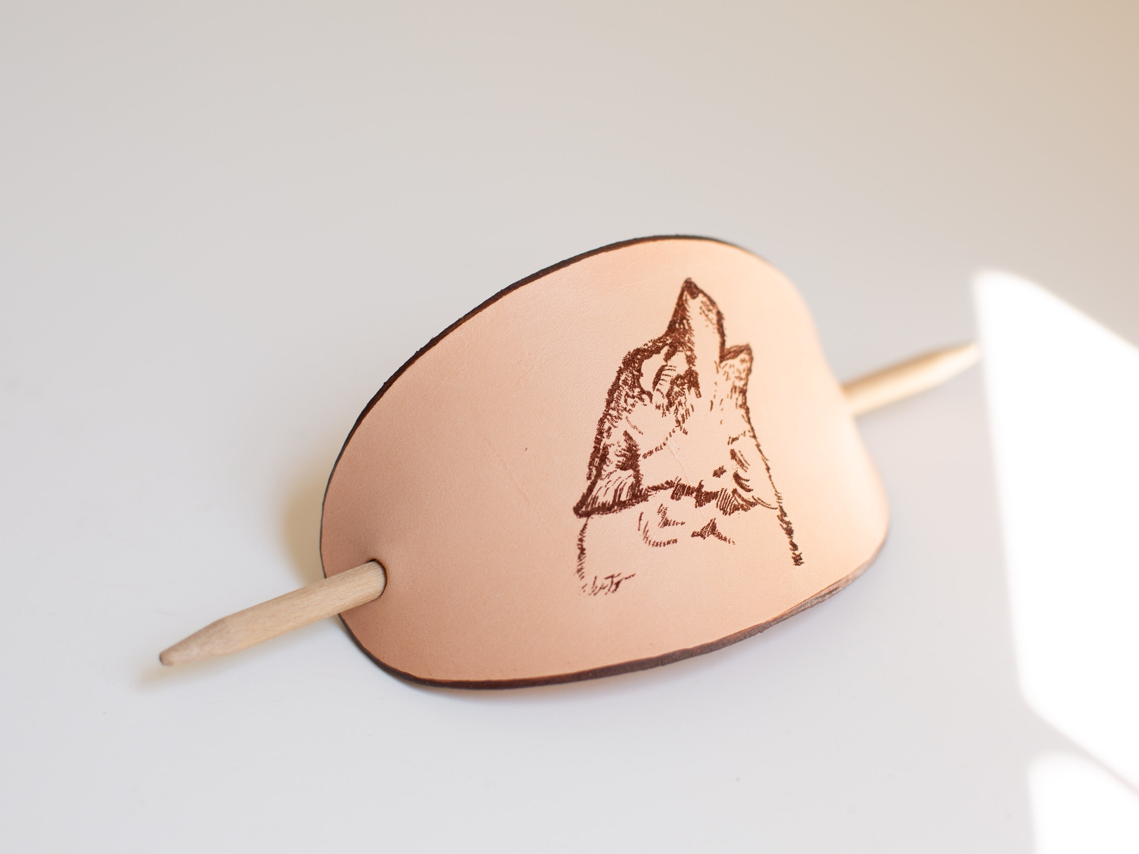 The large leather barrette has a laser engraved wolf design that is a digitalized original art drawing. 