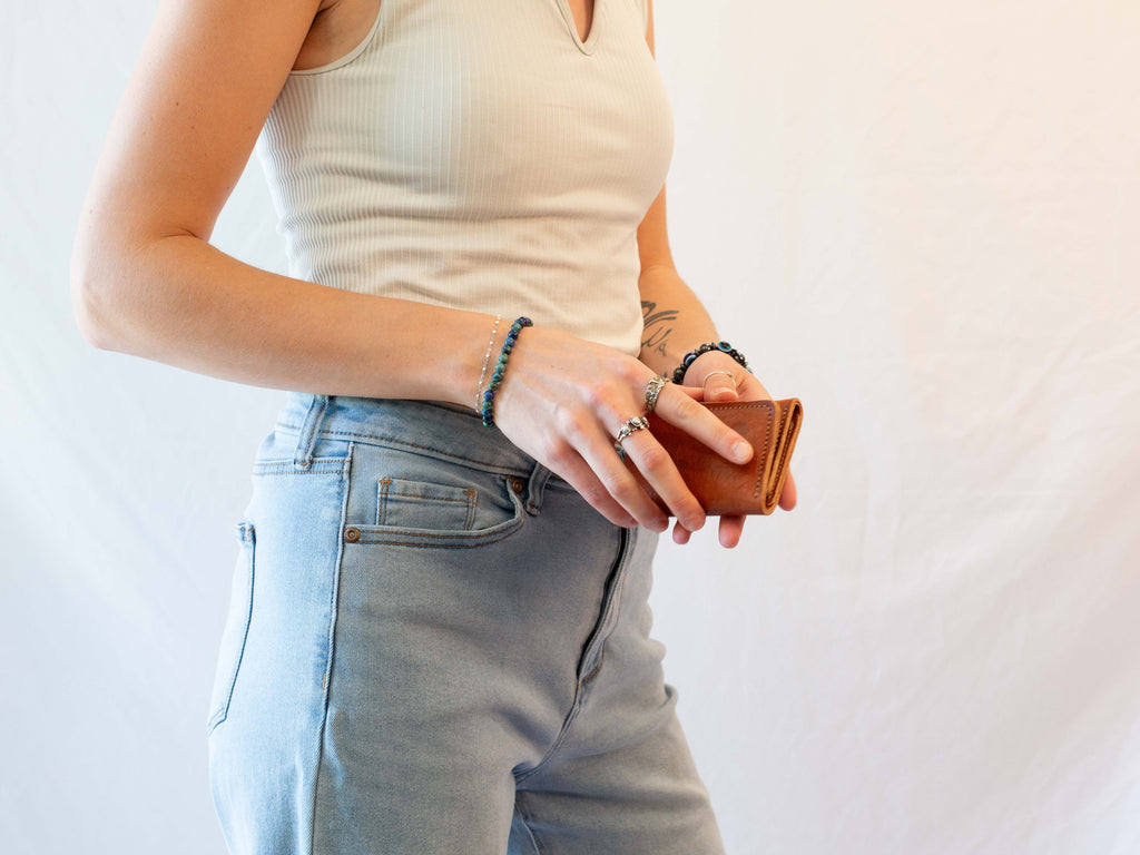 The organic leather wallet is securely shut with snaps, making it small and easy to carry in the pocket. 