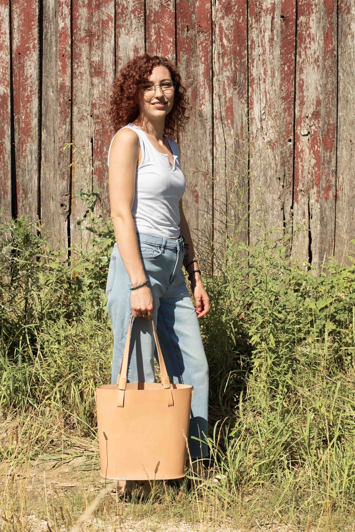 The leather market bag is carried by a model to show how it looks when in use. 