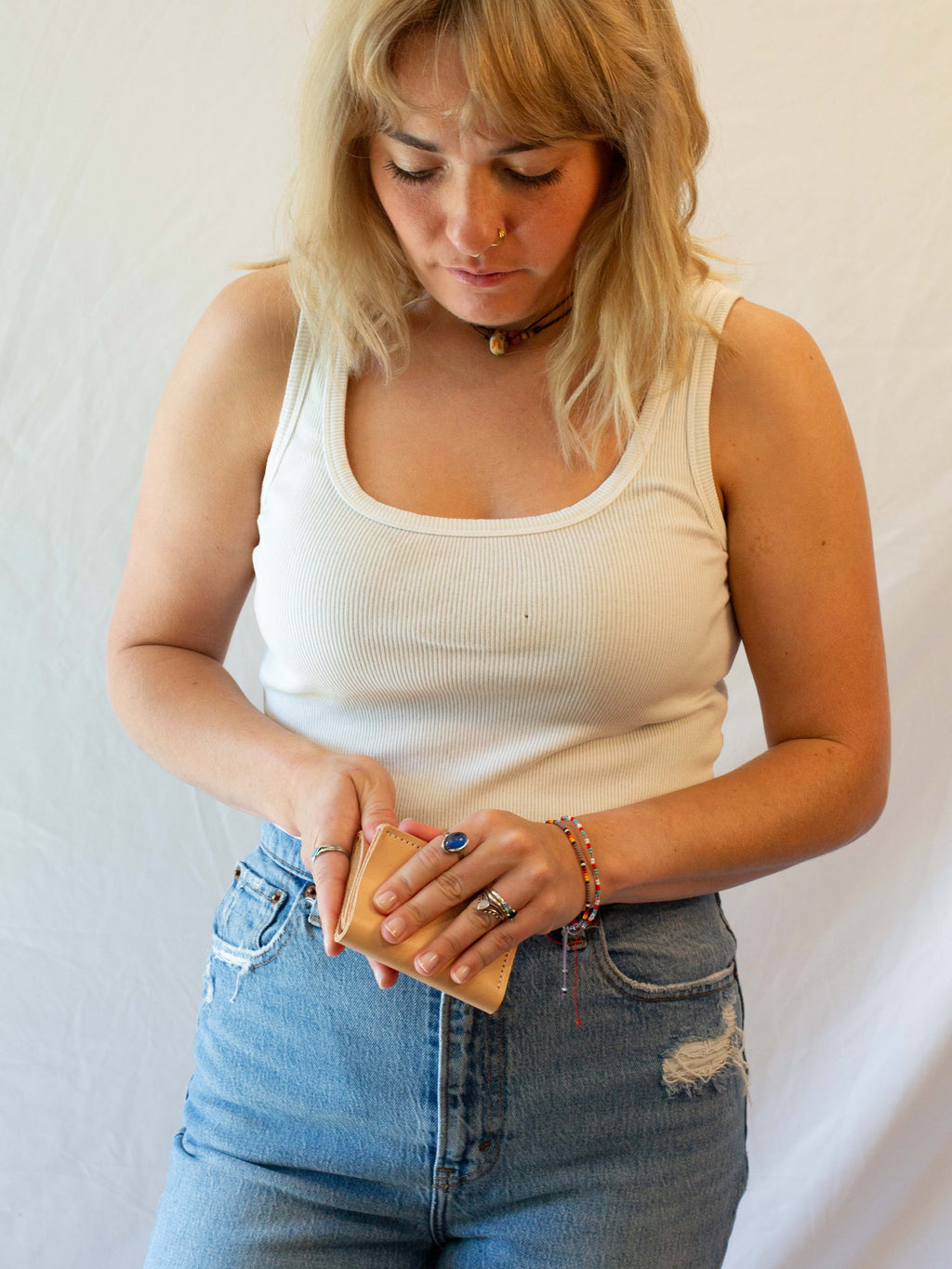 A woman is opening the leather card wallet while opening it. 
