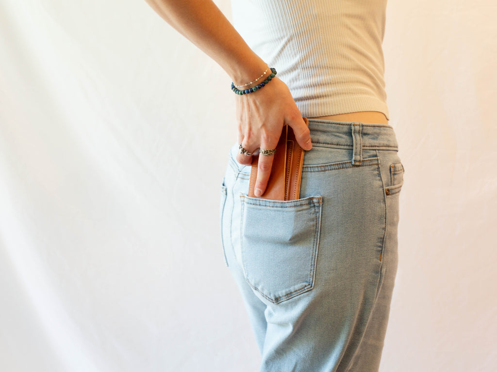 The model is showing how the organic leather cash wallet fits in pants pockets. 