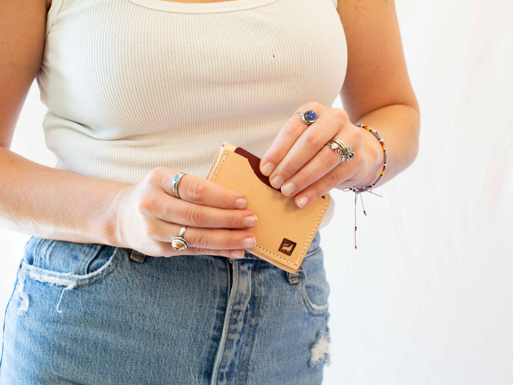 On the backside of the small leather coin wallet is the card pocket. On the card slot the branded logo of White Wolf Leather Studio is visible. 