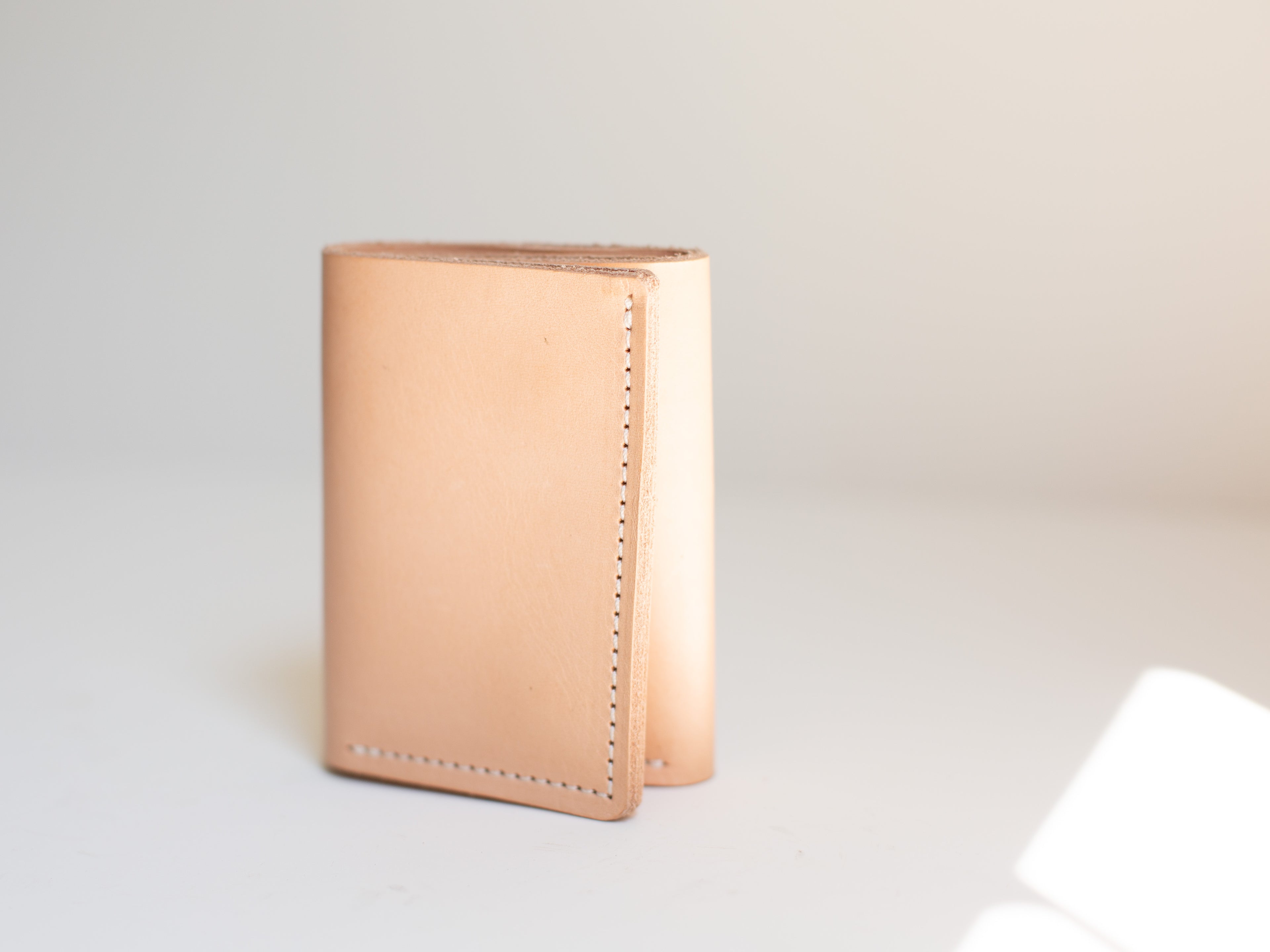 The trifold card and cash wallet is shown closed to show the clean seams and minimalist design. 