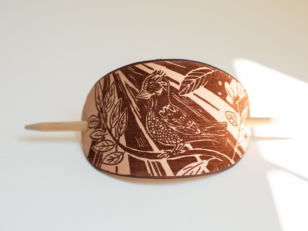The hair slide is made with organic non-toxic veg tan leather and large. It works well for long and thick hair and for messy buns. 