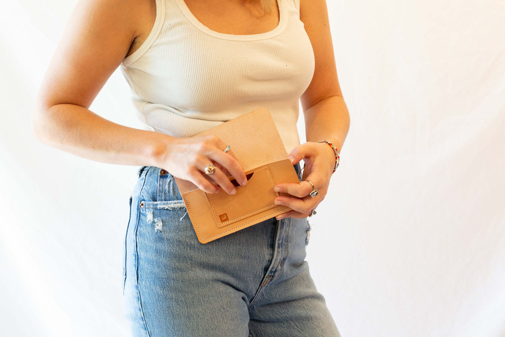 The model is opening the wallet so you can see the logo of White Wolf Leather Studio that is stamped on the card pocket. 