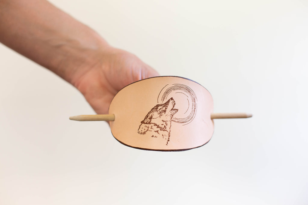 The leather barrette is made with sustainable organic leather and has a laser engraving of a howling moon after an original art drawing. 